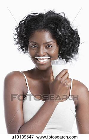 Stock Photo - Portrait of happy young woman with milk moustache holding glass of milk. Fotosearch