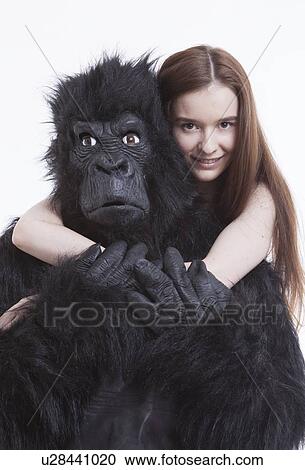 Portrait of smiling young woman hugging man in gorilla costume against white background View Large Photo Image Stock Image - Portrait of smiling young woman hugging man in gorilla costume against white background. Fotosearch