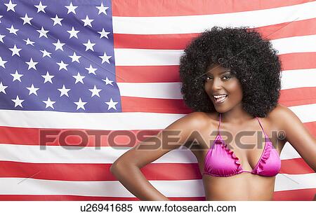 Portrait of stylish young woman in bikini standing against American flag View Large Photo Image Stock Photography - Portrait of stylish young woman in bikini standing against American flag. Fotosearch