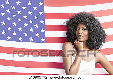 Portrait of stylish young woman with fizzy hairstyle standing against American flag View Large Photo Image Stock Image - Portrait of stylish young woman with fizzy hairstyle standing against American flag. Fotosearch