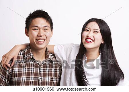 Stock Image - Portrait of young Asian friends smiling together over white background. Fotosearch