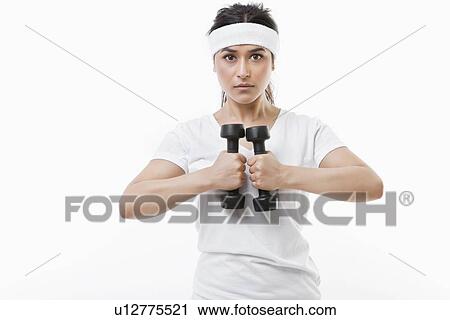 Portrait of young Asian sportswoman raising dumbbell over white background View Large Photo Image Stock Image - Portrait of young Asian sportswoman raising dumbbell over white background. Fotosearch