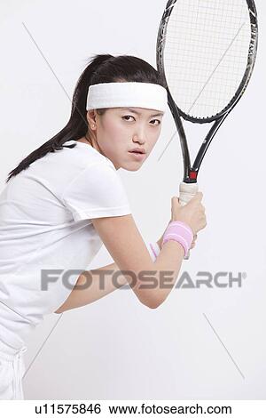 Portrait of young Asian woman holding tennis racket against white background View Large Photo Image Stock Photograph - Portrait of young Asian woman holding tennis racket against white background. Fotosearch