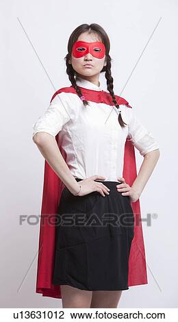 Portrait of young Asian woman in superhero costume with hands on hips against white background View Large Photo Image Stock Image - Portrait of young Asian woman in superhero costume with hands on hips against white background. Fotosearch