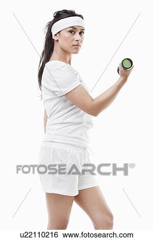 Portrait of young Asian woman raising dumbbell over white background View Large Photo Image Stock Photograph - Portrait of young Asian woman raising dumbbell over white background. Fotosearch