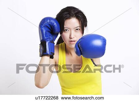 Portrait of young Asian woman wearing blue boxing gloves against white background View Large Photo Image Stock Photo - Portrait of young Asian woman wearing blue boxing gloves against white background. Fotosearch