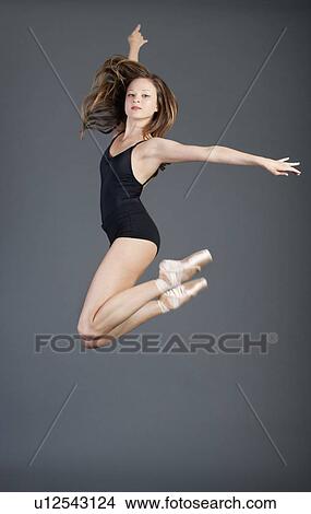 Portrait of young ballet dancer in mid-air over grey background View Large Photo Image Picture - Portrait of young ballet dancer in mid-air over grey background. Fotosearch