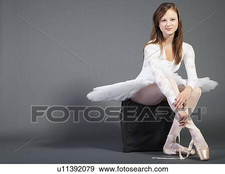 Portrait of young ballet dancer sitting against grey background View Large Photo Image Stock Photo - Portrait of young ballet dancer sitting against grey background. Fotosearch