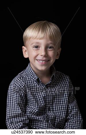 Stock Image - Portrait of young boy over black background. Fotosearch
