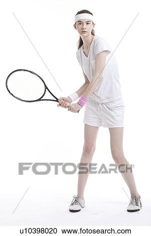 Stock Image - Portrait of young Caucasian woman with tennis racket against white background. Fotosearch