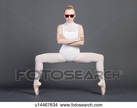 Portrait of young female ballet dancer tiptoeing over grey background View Large Photo Image Picture - Portrait of young female ballet dancer tiptoeing over grey background. Fotosearch