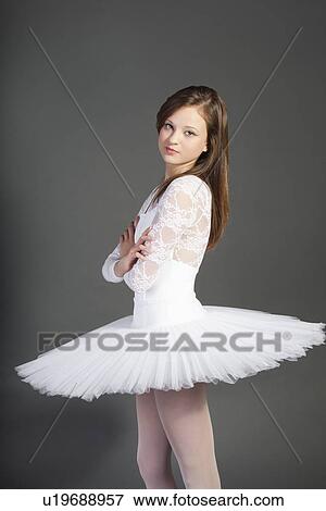 Portrait of young female ballet dancer with arms crossed standing over grey background View Large Photo Image Stock Photo - Portrait of young female ballet dancer with arms crossed standing over grey background. Fotosearch