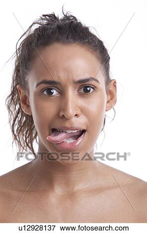 Stock Photo - Portrait of young Mixed Race woman sticking out her tongue against white background. Fotosearch