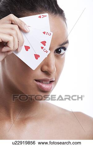 Portrait of young Mixed Race woman covering her eye with playing card against white background View Large Photo Image Stock Photograph - Portrait of young Mixed Race woman covering her eye with playing card against white background. Fotosearch