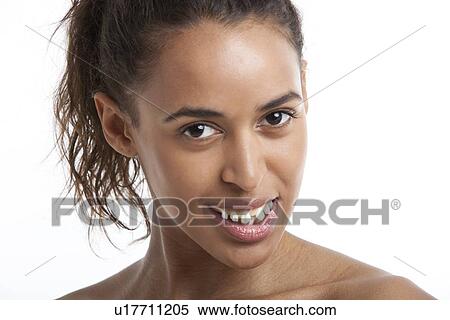 Stock Photography - Portrait of young Mixed Race woman suffering from headache against white background. Fotosearch