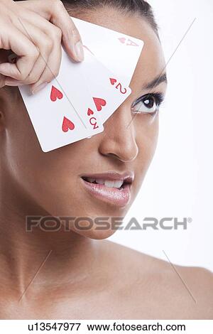 Portrait of young Mixed Race woman with playing cards biting her lip against white background View Large Photo Image Stock Photo - Portrait of young Mixed Race woman with playing cards biting her lip against white background. Fotosearch