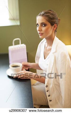 Stock Photo - Portrait of young woman having coffee. Fotosearch