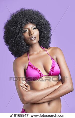 Portrait of young woman in bikini standing over violet background View Large Photo Image Stock Photo - Portrait of young woman in bikini standing over violet background. Fotosearch