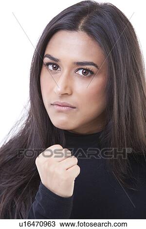 Portrait of young woman with clenched fist against white background View Large Photo Image Stock Image - Portrait of young woman with clenched fist against white background. Fotosearch