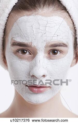 Portrait of young woman with face pack and towel wrapped around head against white background View Large Photo Image Stock Photograph - Portrait of young woman with face pack and towel wrapped around head against white background. Fotosearch