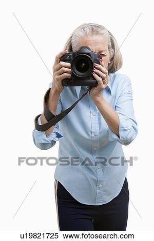 Senior female photographer using camera against white background View Large Photo Image Stock Photography - Senior female photographer using camera against white background. Fotosearch