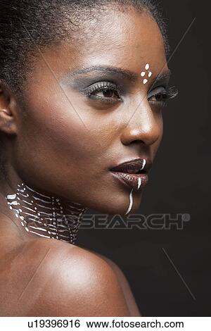 Side-on view of beautiful woman wearing tribal make-up paint View Large Photo Image Stock Photograph - Side-on view of beautiful woman wearing tribal make-up paint . Fotosearch