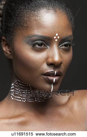 Stock Photography - Side-on view of beautiful woman wearing tribal make-up paint . Fotosearch
