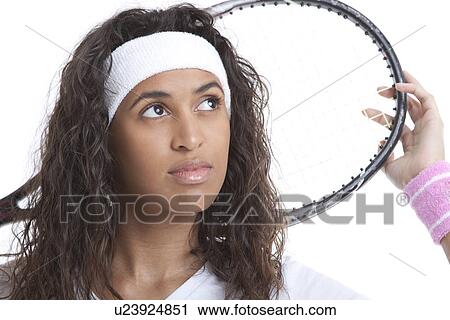Sporty young woman with tennis racket looking away against white background View Large Photo Image Stock Image - Sporty young woman with tennis racket looking away against white background. Fotosearch