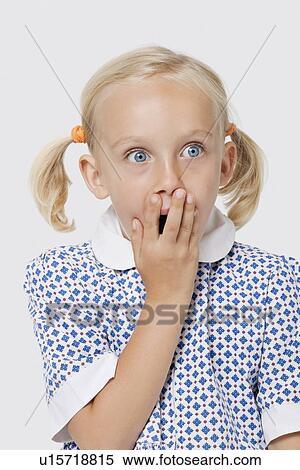 Surprised young girl covering mouth with her hand over white background View Large Photo Image Stock Photography - Surprised young girl covering mouth with her hand over white background. Fotosearch