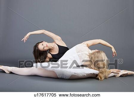 Two young female ballet dancers doing the splits over grey background View Large Photo Image Stock Photography - Two young female ballet dancers doing the splits over grey background. Fotosearch