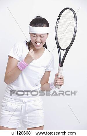 Young Asian female tennis player celebrating her success against white background View Large Photo Image Stock Image - Young Asian female tennis player celebrating her success against white background. Fotosearch