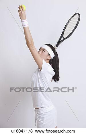 Young Asian female tennis player serving against white background View Large Photo Image Stock Photo - Young Asian female tennis player serving against white background. Fotosearch