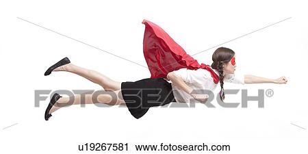 Stock Image - Young Asian woman in superhero costume in flying pose against white background. Fotosearch