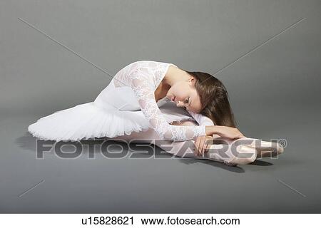 Young ballet dancer wearing white tutu sitting over grey background View Large Photo Image Stock Image - Young ballet dancer wearing white tutu sitting over grey background. Fotosearch