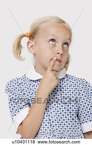 Stock Photo - Young Caucasian girl thinking with finger on lips over white background. Fotosearch