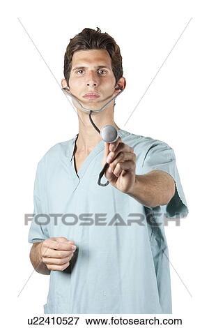 Young doctor wearing scrubs holding stethoscope to camera View Large Photo Image Stock Photo - Young doctor wearing scrubs holding stethoscope to camera. Fotosearch