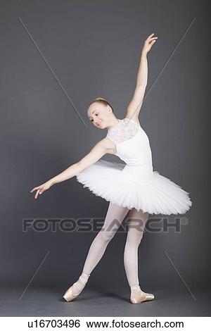 Young female ballet dancer dancing over grey background View Large Photo Image Stock Photograph - Young female ballet dancer dancing over grey background. Fotosearch