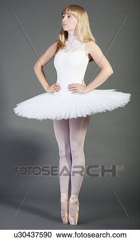 Young female ballet dancer in wearing tutu tiptoeing over grey background View Large Photo Image Stock Image - Young female ballet dancer in wearing tutu tiptoeing over grey background. Fotosearch