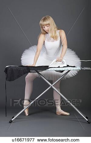 Young female ballet dancer ironing over grey background View Large Photo Image Stock Photo - Young female ballet dancer ironing over grey background. Fotosearch
