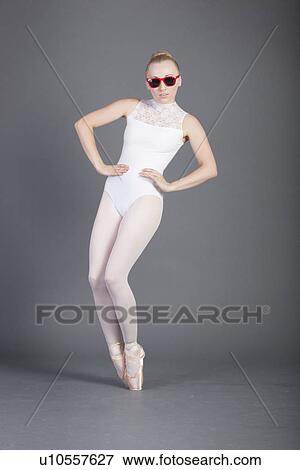 Young female ballet dancer tiptoeing in sunglasses over grey background View Large Photo Image Stock Photo - Young female ballet dancer tiptoeing in sunglasses over grey background. Fotosearch