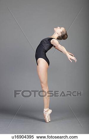 Stock Photography - Young female ballet dancer tiptoeing over grey background. Fotosearch
