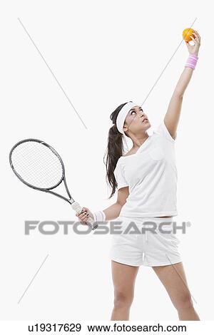 Young female tennis player holding orange and racket against white background View Large Photo Image Stock Photo - Young female tennis player holding orange and racket against white background. Fotosearch