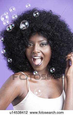 Young Female with Afro amazed at seeing bubbles View Large Photo Image Stock Image - Young Female with Afro amazed at seeing bubbles. Fotosearch