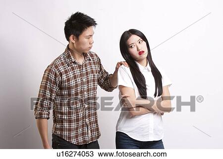 Stock Image - Young man convincing beautiful woman over white background. Fotosearch