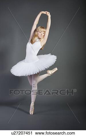 Young woman in white tutu performing ballet over grey background View Large Photo Image Stock Image - Young woman in white tutu performing ballet over grey background. Fotosearch