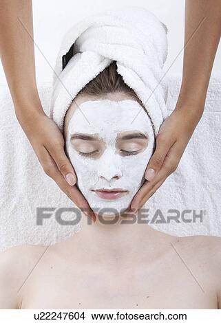 Picture - Young woman receiving facial treatment at spa. Fotosearch