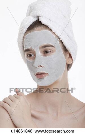 Young woman with face pack and towel wrapped around head looking away against white background View Large Photo Image Stock Photograph - Young woman with face pack and towel wrapped around head looking away against white background. Fotosearch