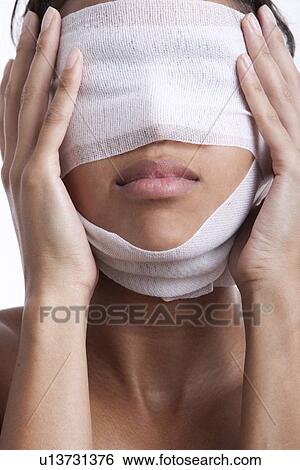 Young woman with head wrapped in bandage against white background View Large Photo Image Stock Photograph - Young woman with head wrapped in bandage against white background. Fotosearch