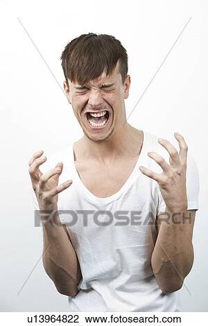Aggressive young man screaming against white background View Large Photo Image Stock Image - Aggressive young man screaming against white background. Fotosearch
