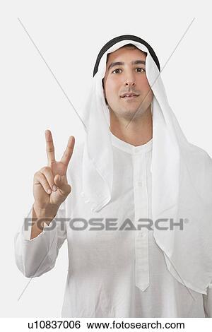 An Arab man gesturing V-sign over white background View Large Photo Image Stock Photograph - An Arab man gesturing V-sign over white background. Fotosearch